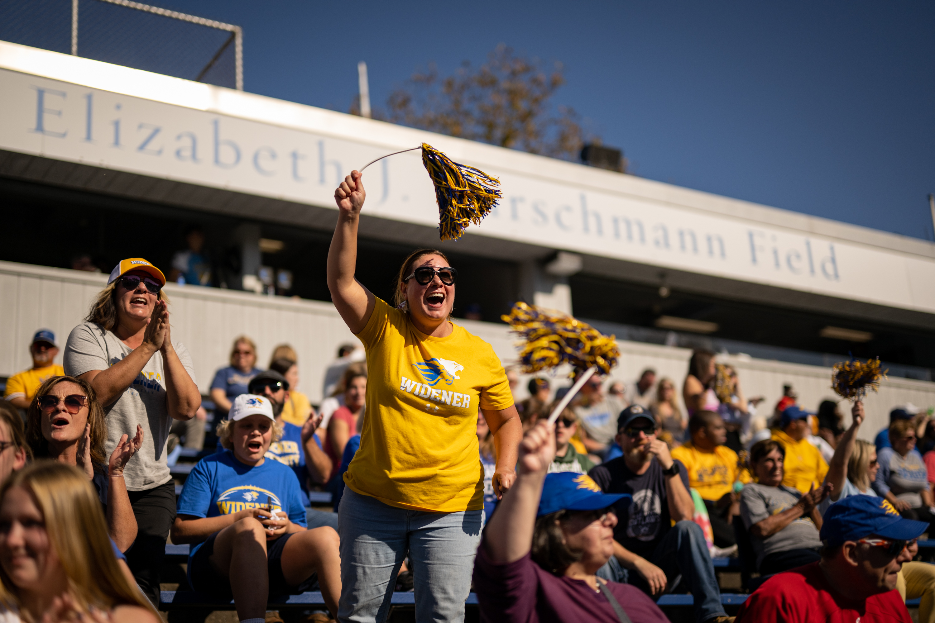 A parent cheers in the stands at Homecoming.